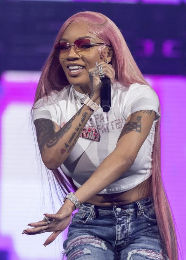 GloRilla, a woman with pink hair and tattoos, performing on stage at Little Caesars Arena in Detroit, Michigan on January 19, 2024