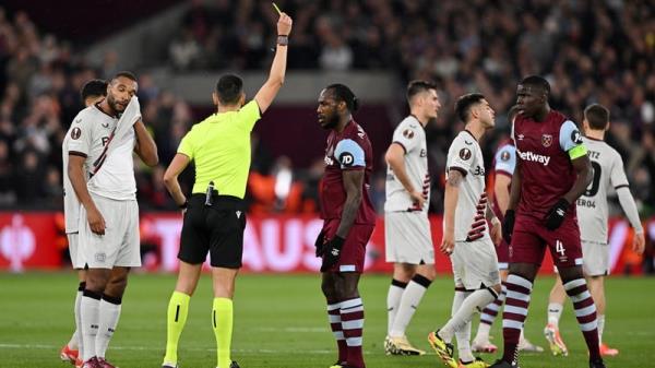 Referee Jose Sanchez shows a yellow card to both Michail Anto<em></em>nio of West Ham United and Jo<em></em>nathan Tah of Bayer Leverkusen